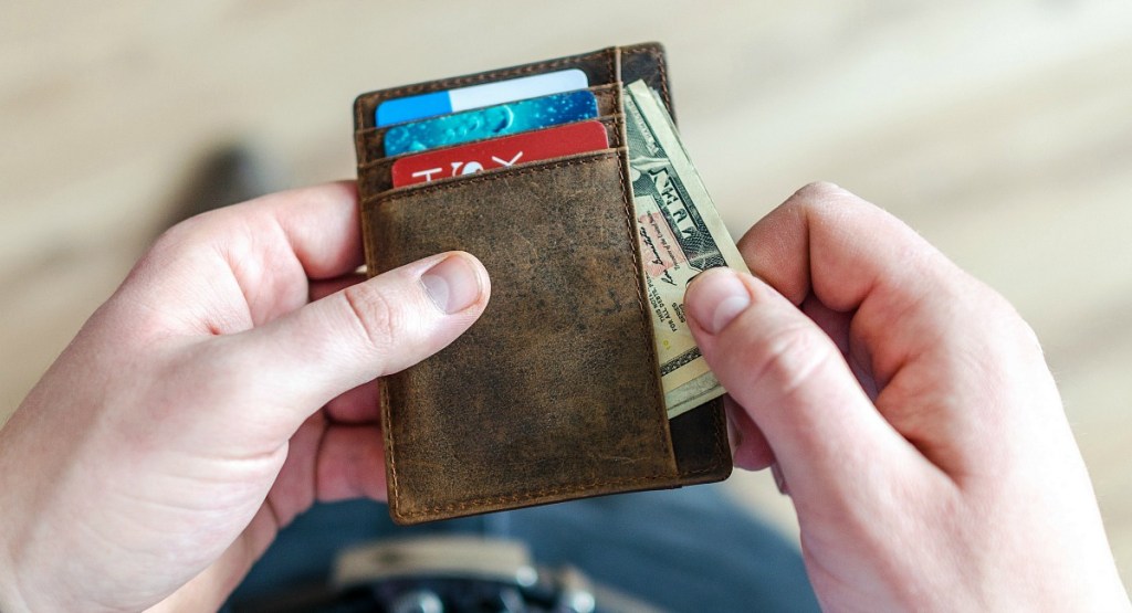 man getting cash out of wallet