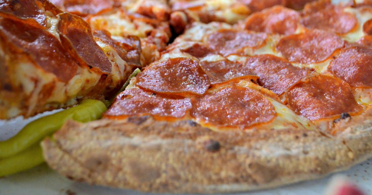 closeup of a pizza with a banana pepper