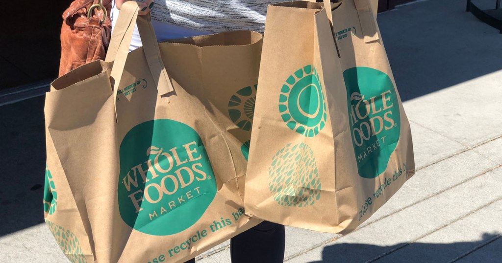 woman carrying Whole Foods shopping bags