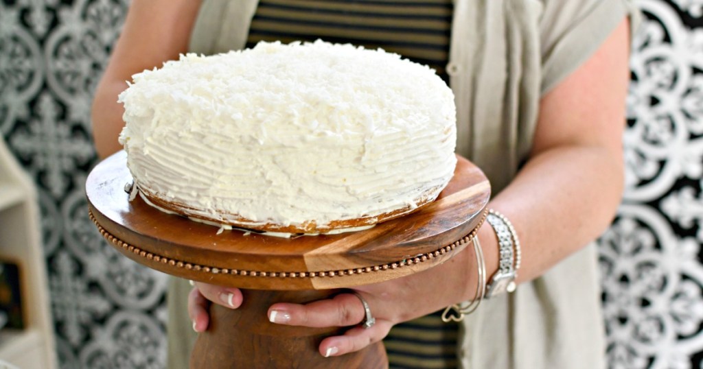 woman holding a coconut sour cream cake