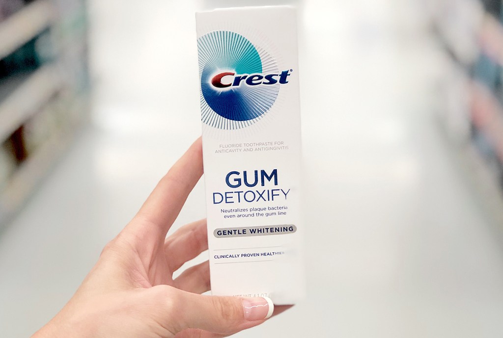 Box of Crest-brand gum detoxify toothpaste in hand in store