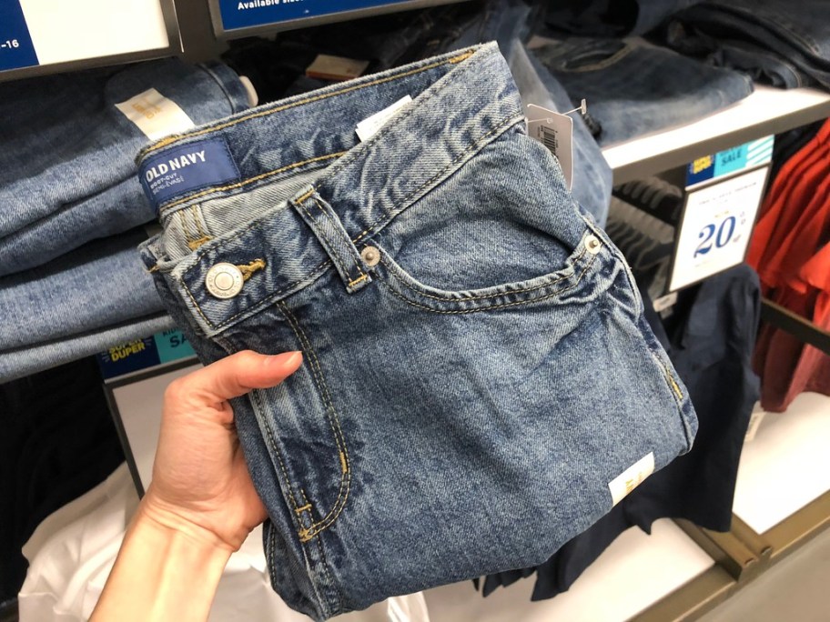 A woman holding a pair of Old Navy denim pants