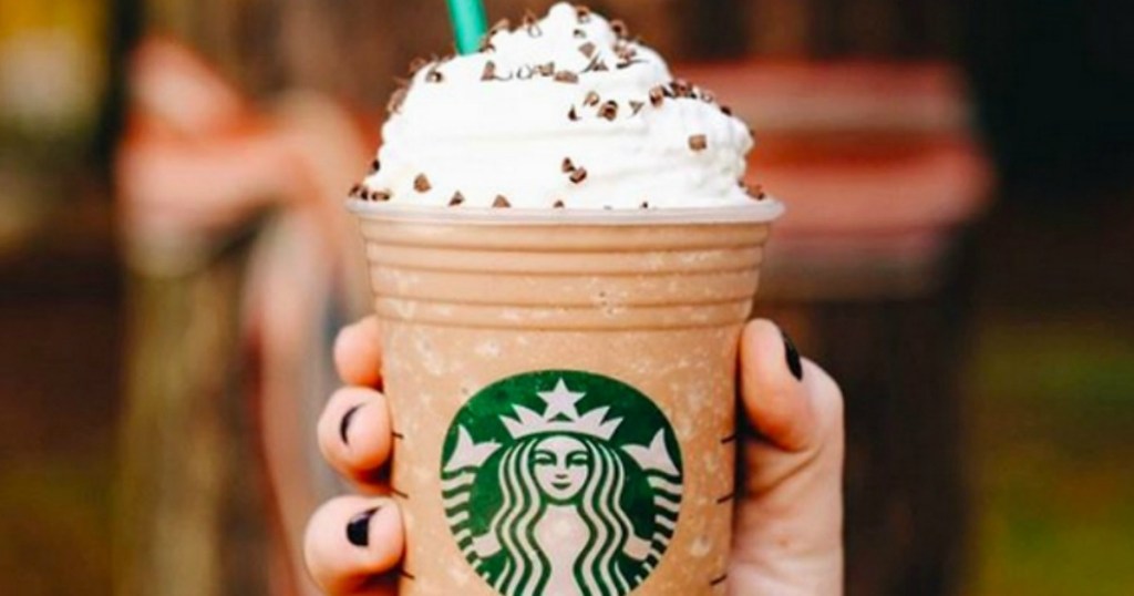 holding Starbucks drink with whipped cream