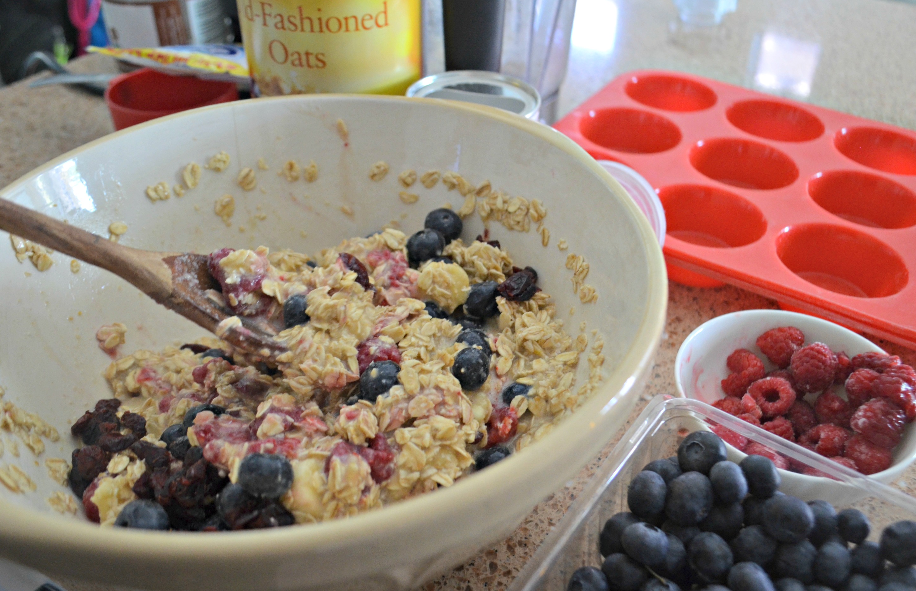 Baked Oatmeal Berry Cups – mixing the ingredients in a bowl with a wooden spoon