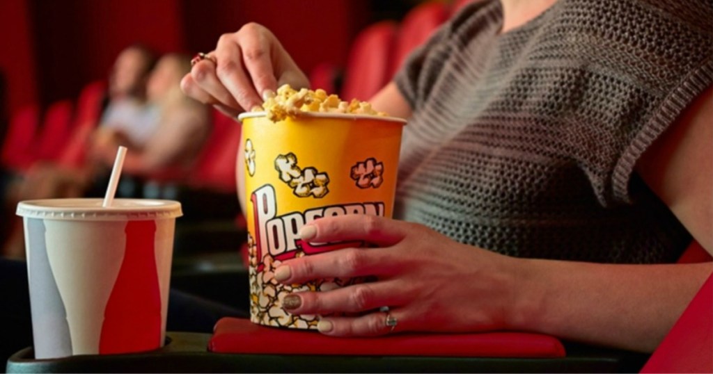 person at movies with popcorn and drink