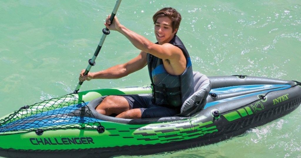 man in kayak on lake with oar