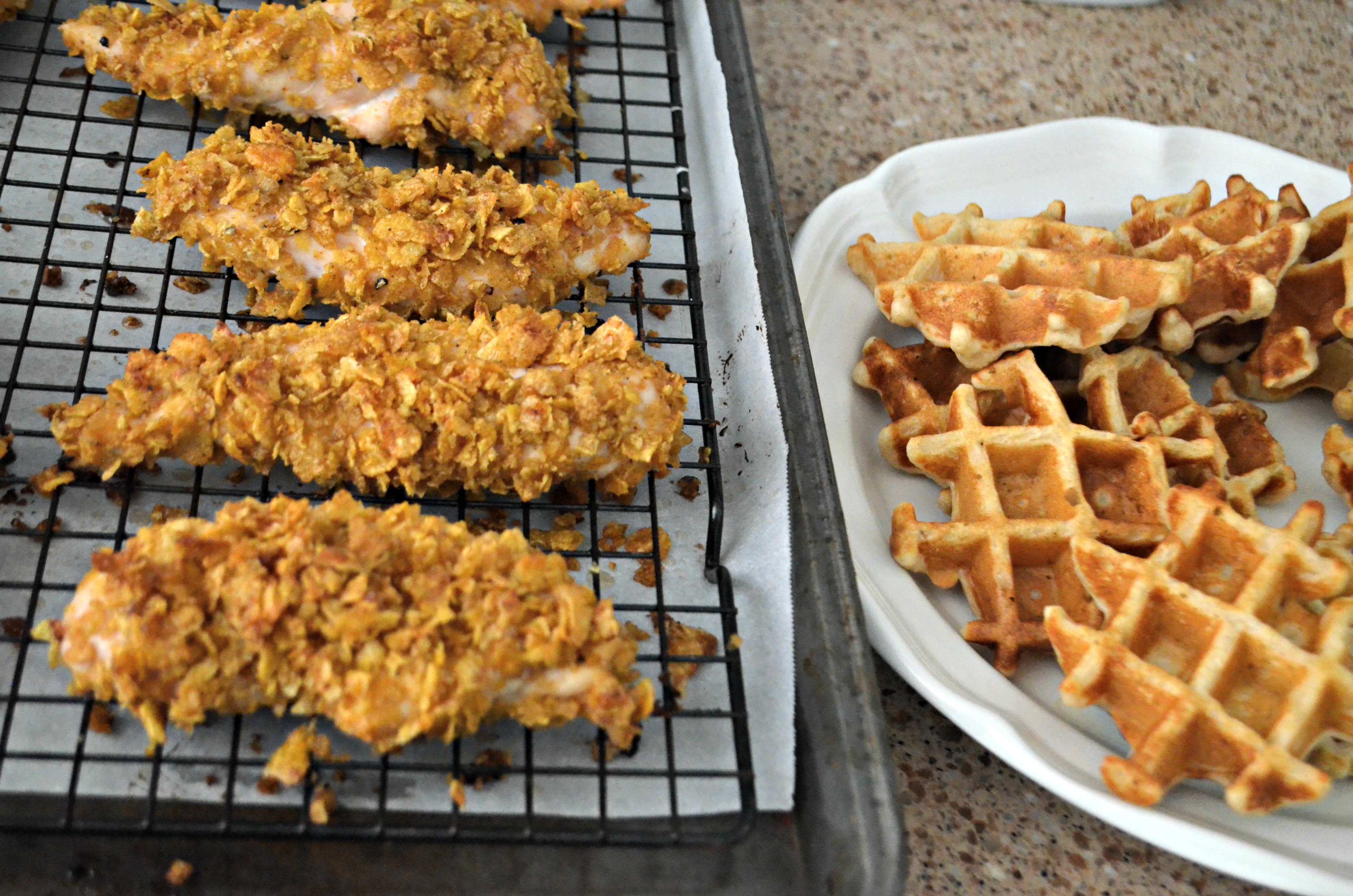 Easy Cornflake Chicken and Mini Waffles - chicken on the baking rack next to the waffles on a plate