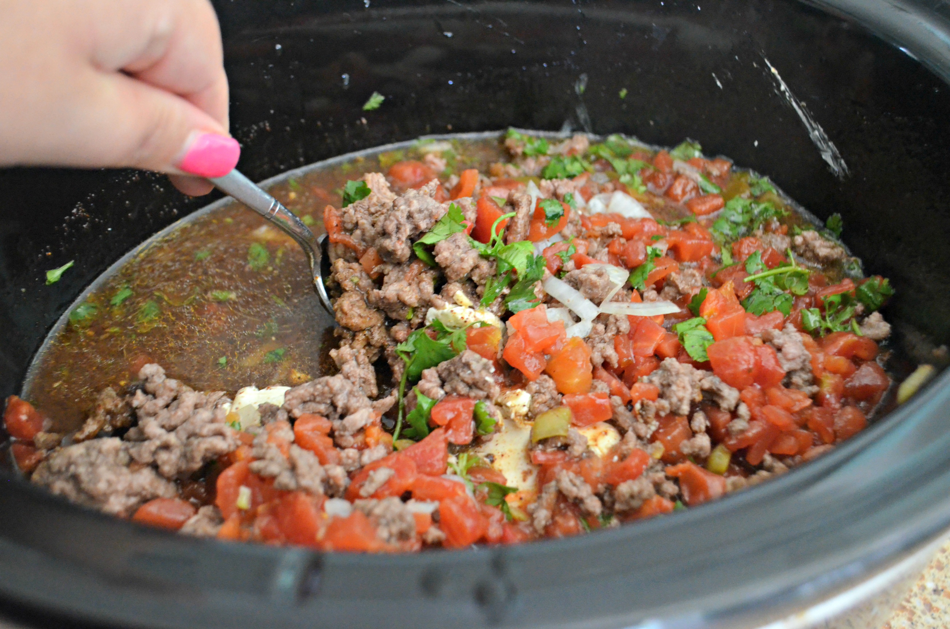 Stirring this easy slow cooker keto taco soup with a spoon