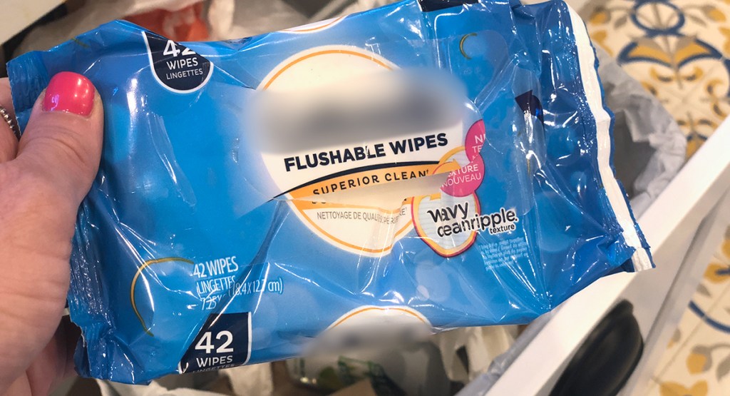 holding up flushable wipes package before being thrown out