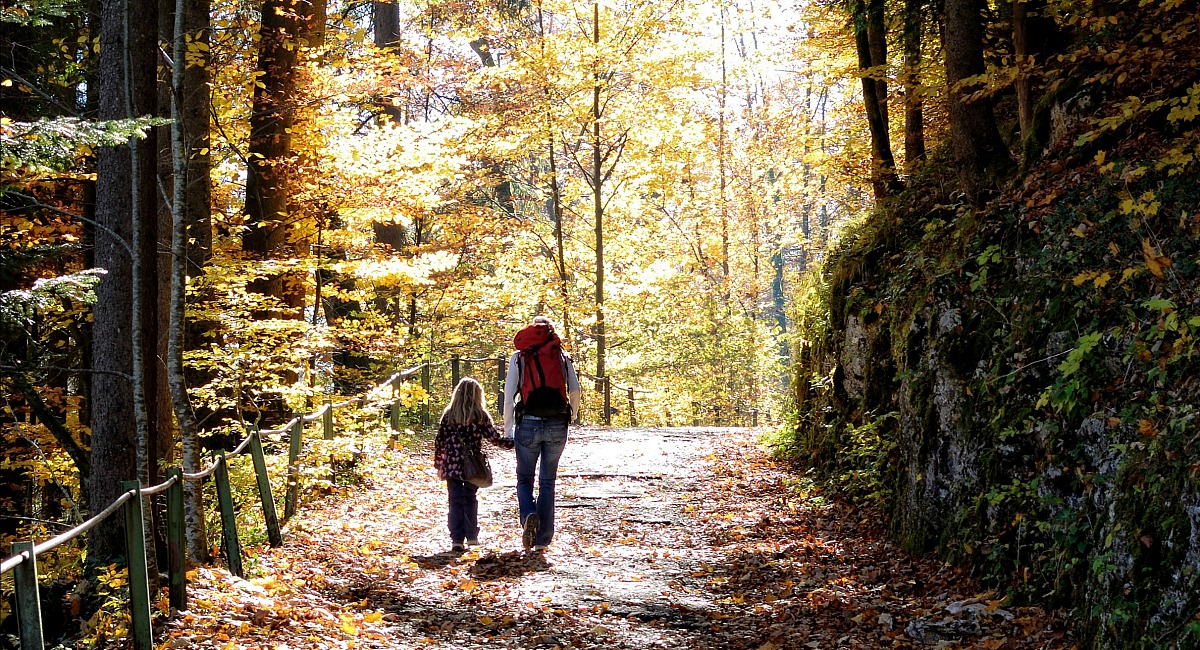 places for free fun fall activities — mother and daughter hiking trail with autumn leaves