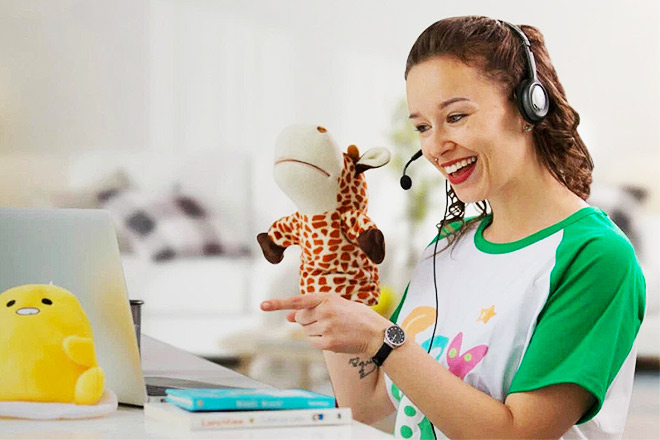 Teacher holding up a stuffed animal to earn money teaching English at home with SayABC.com.