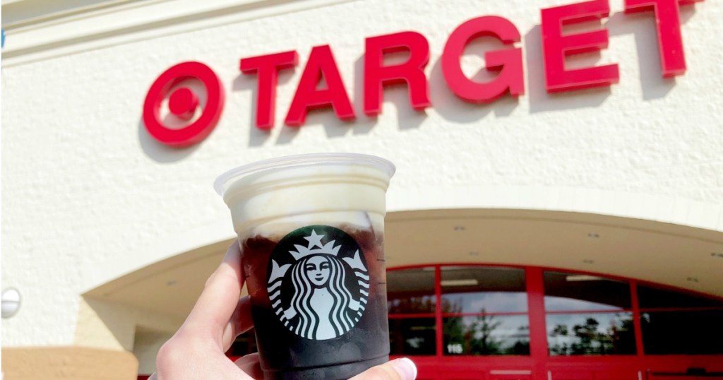 hand holding up a starbucks drink in front of a target store front