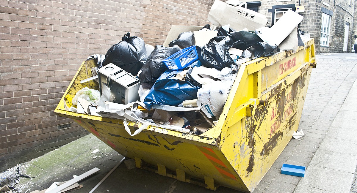 simple tricks & tips for decluttering your home — dumpster full of trash