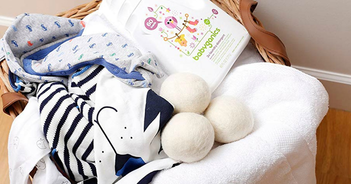 wool dryer balls with baby clothing in a basket