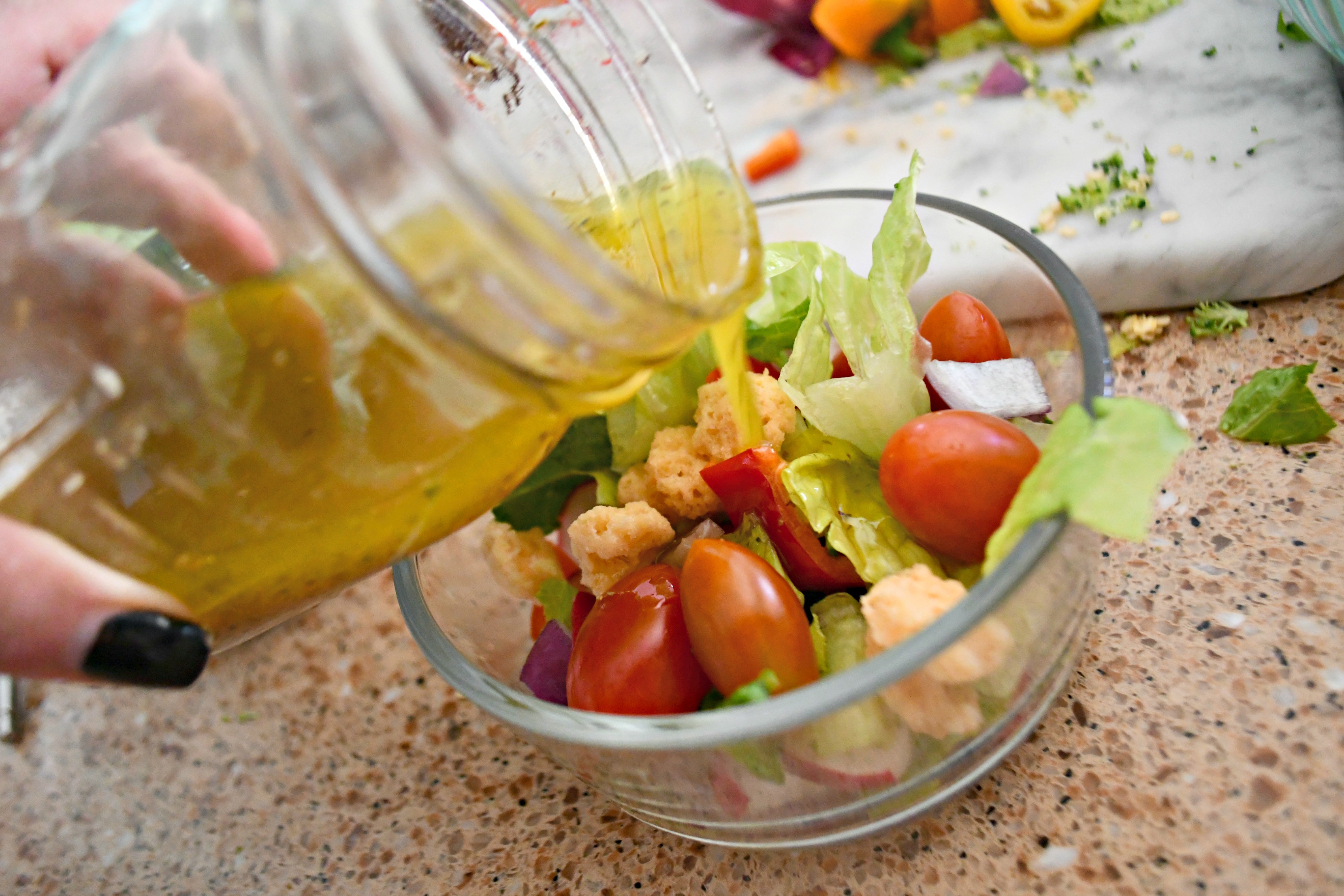 Pouring my favorite salad dressing over my Weekly Sunday Salad Prep