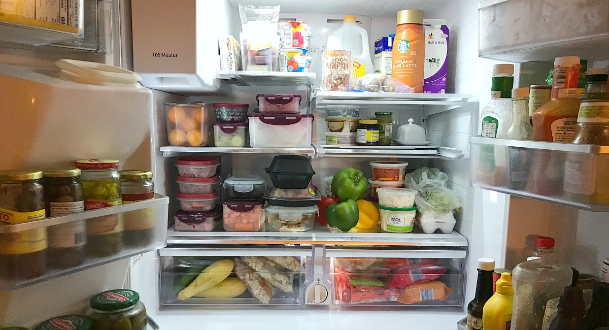 amber's organized meal plans and grocery shops — fridge opened showing pre portioned tupperware containers