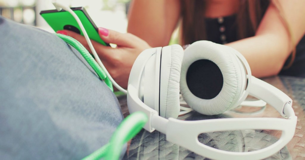 headphones on table by person using phone