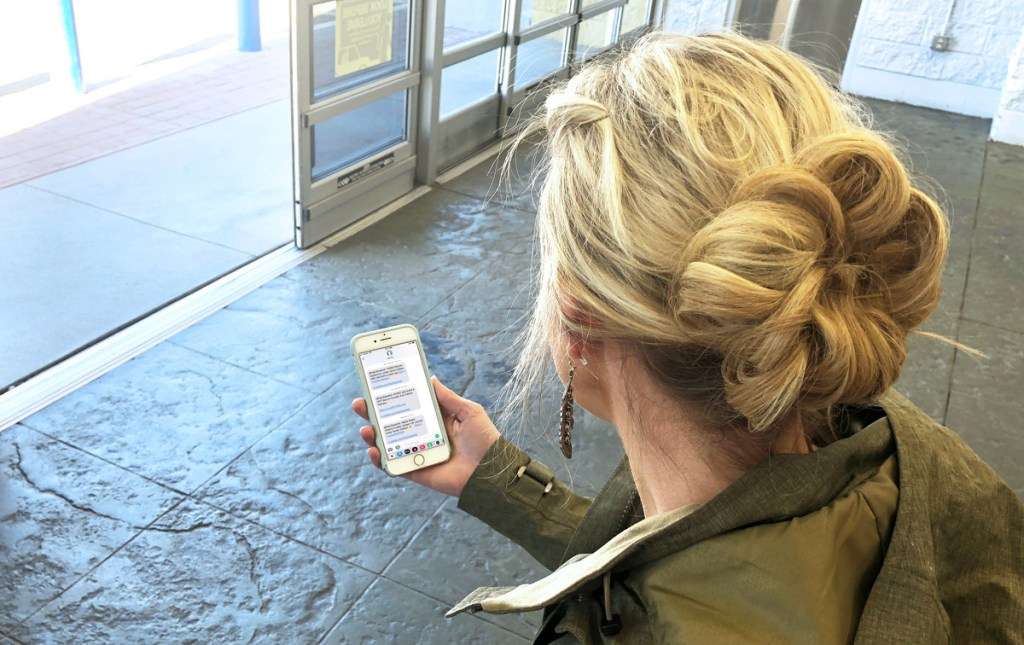 Sign up for hot deal text alerts and never miss a deal — Collin looking at hot text alerts on her phone