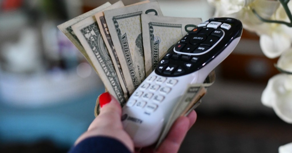 Woman holding DirecTV Remote Control and cash