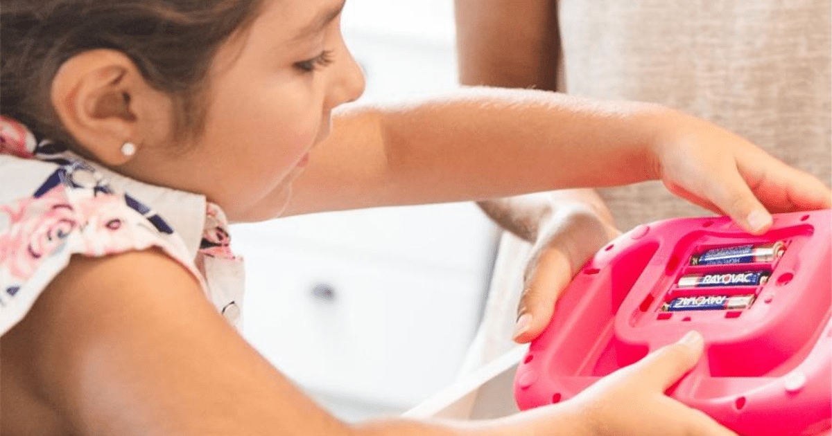 little girl putting batteries in her toy