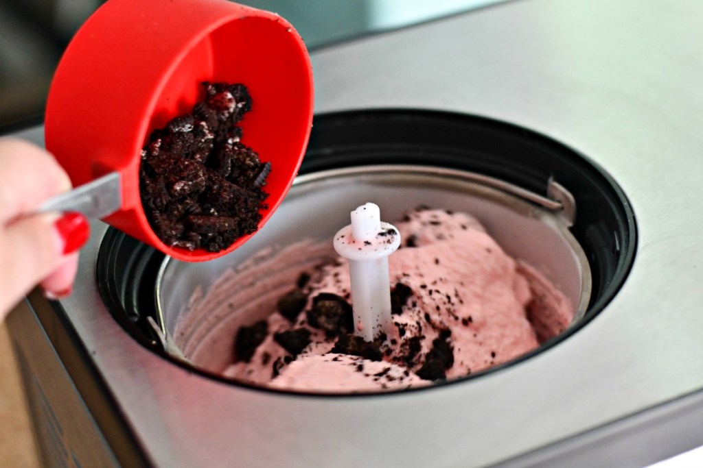 adding crumbled oreos to peppermint ice cream