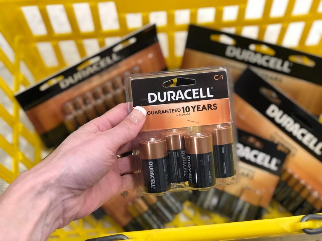 Hand holding Duracell batteries with batteries blurred in the background