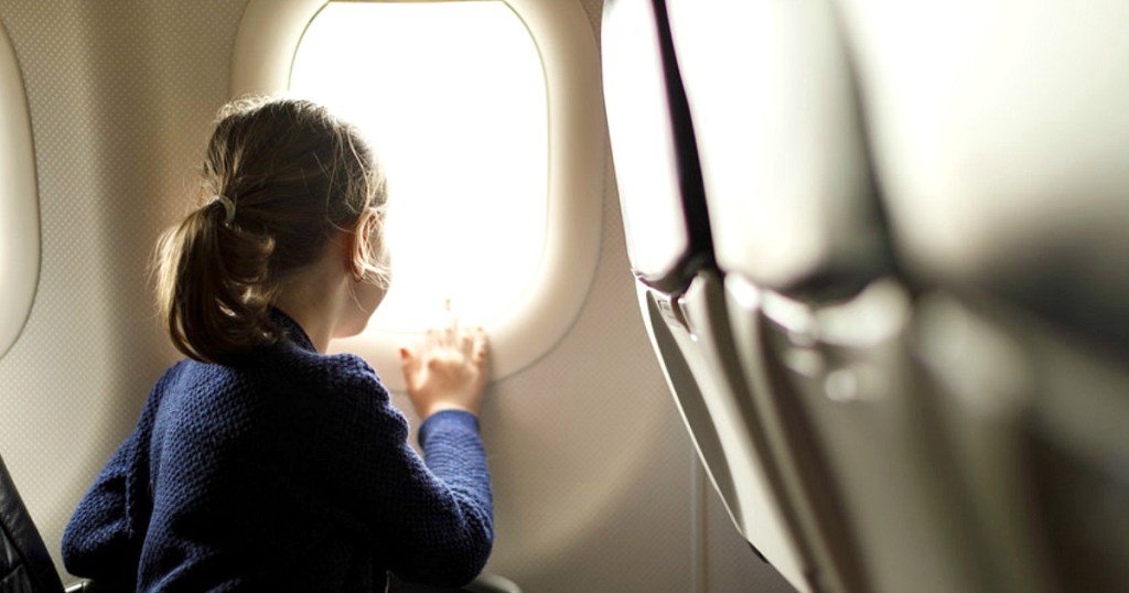 Frontier Airlines offering free flights - child looking out plane window