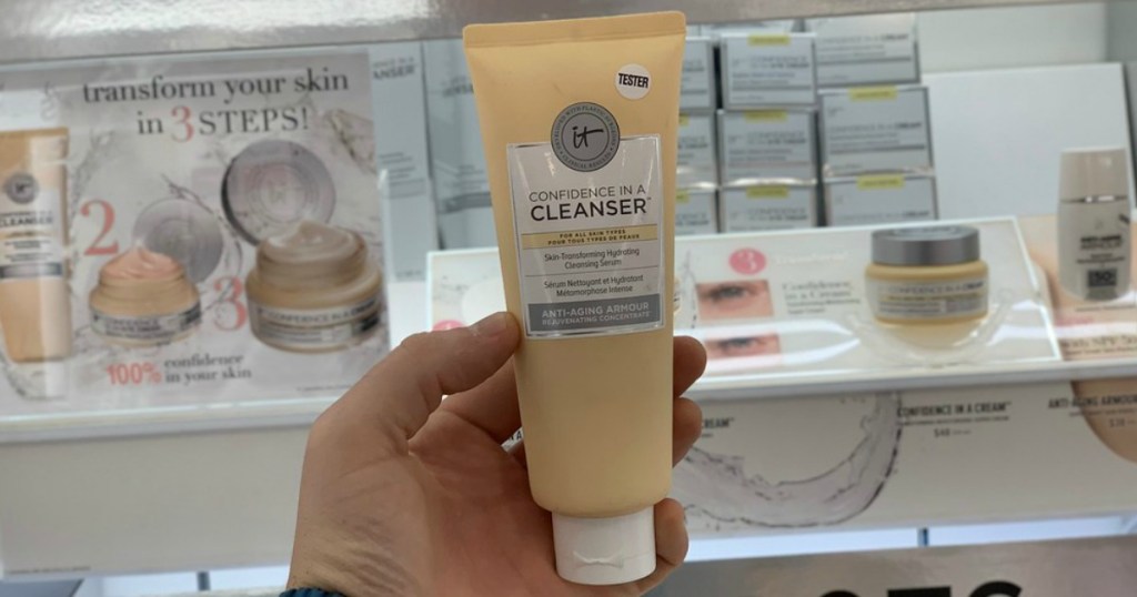 hand holding a bottle of cleanser