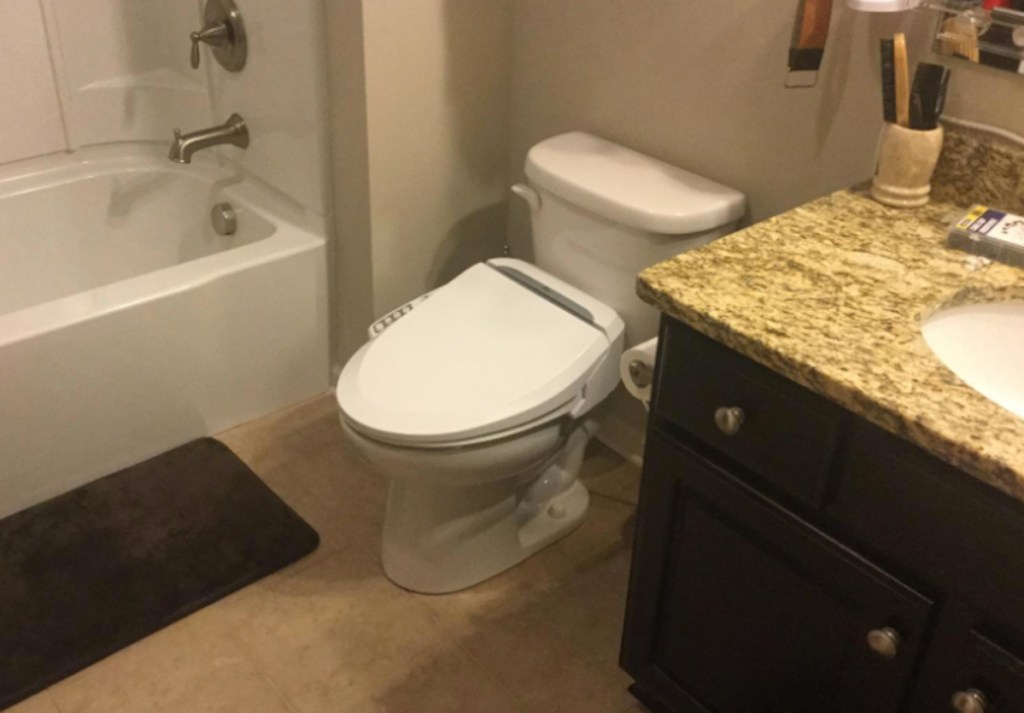 white toilet and sink in bathroom next to shower