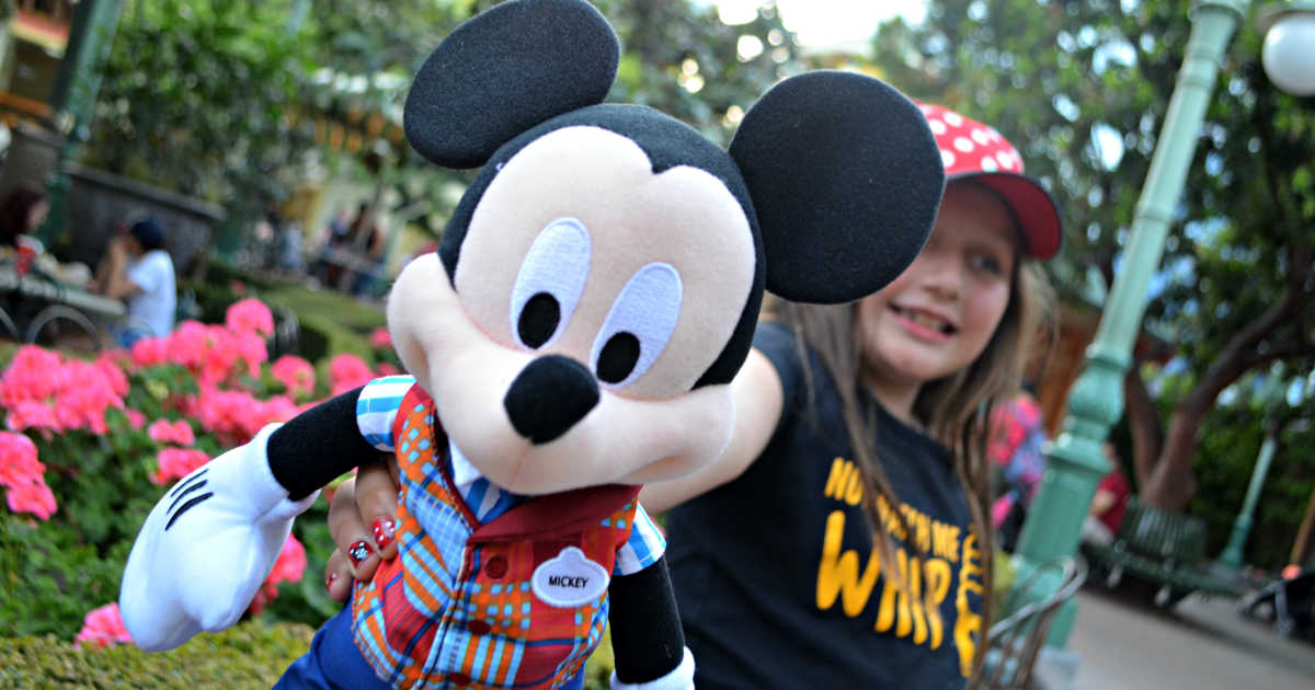 young girl holding a Mickey Mouse doll