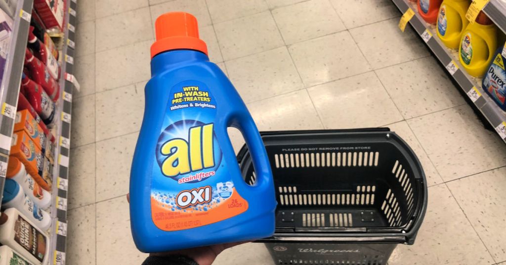 hand holding a bottle of all laundry detergent at Walgreens