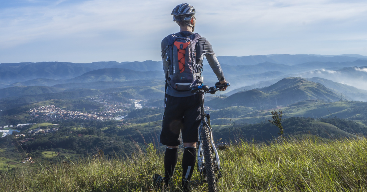 Man looking at view holding onto bike 