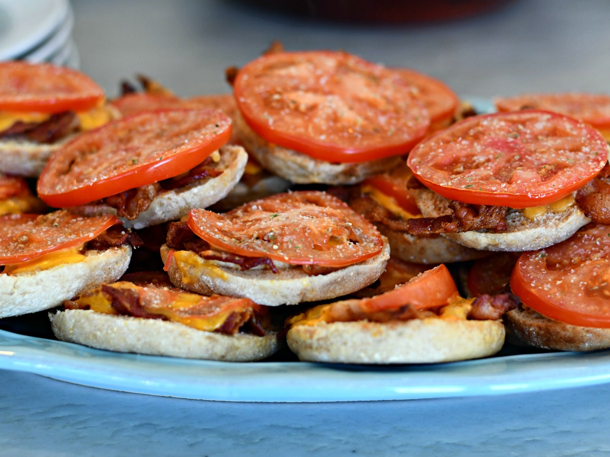 easy bacon and tomato baked english muffins stacked on a serving tray