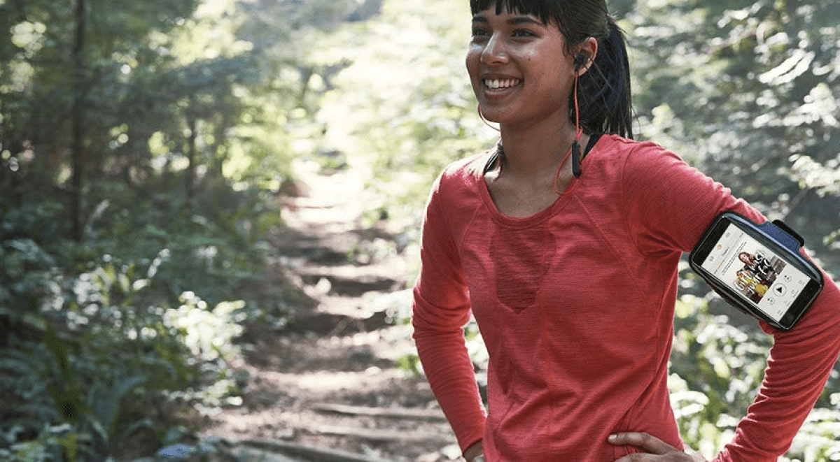woman running and sweaty with phone and headphones in her ears