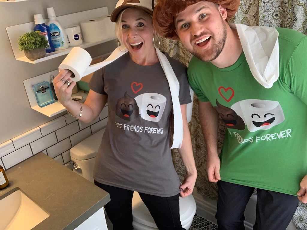 man and woman in bathroom with toilet paper