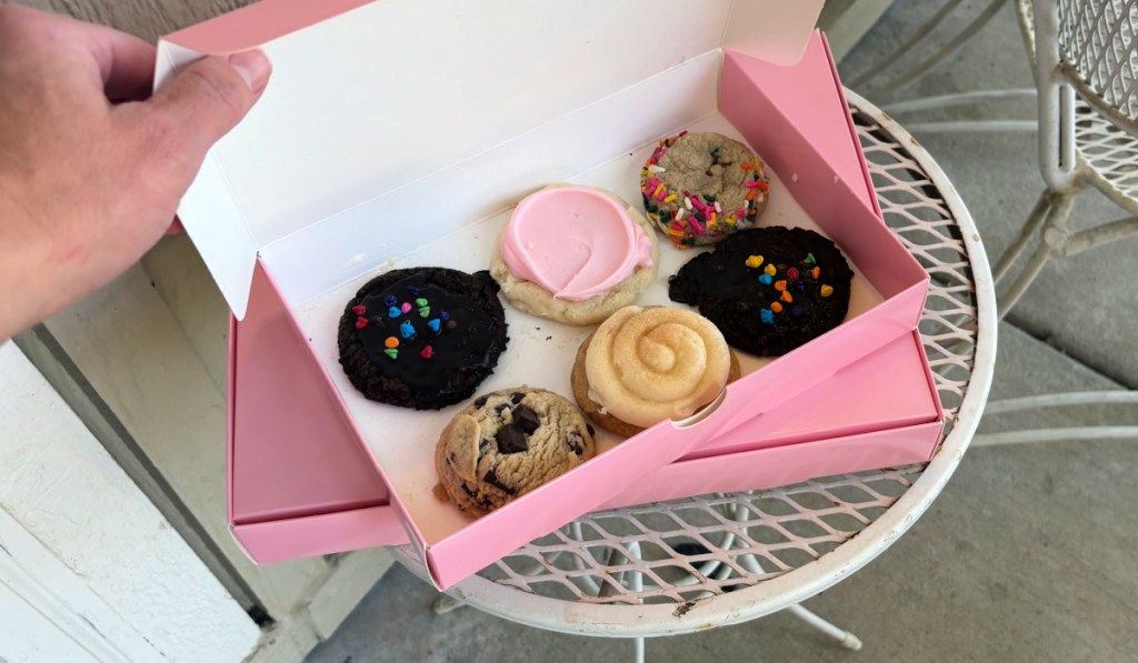Person opening up crumble cookies, box of six mini cookies