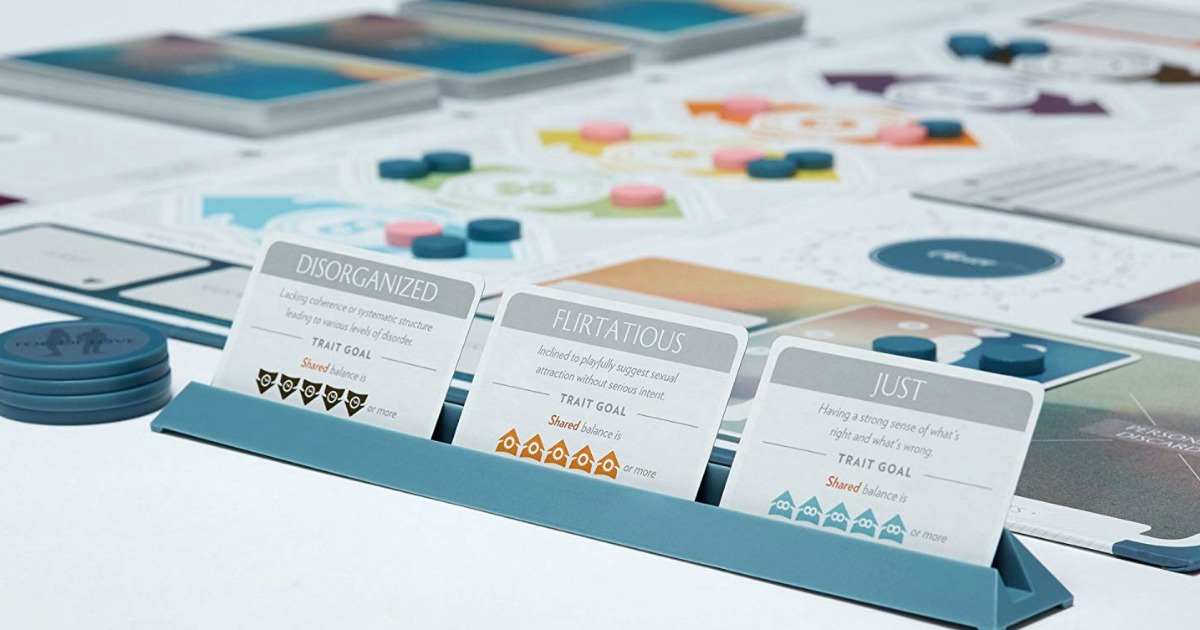 three cards standing in teal tray in front of board game