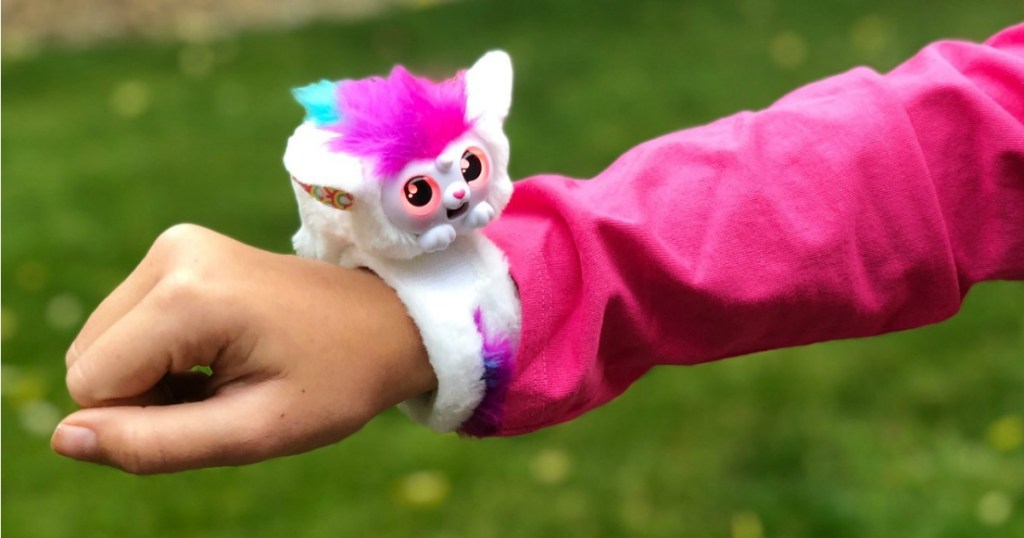 little live wrapples in white and pink on wrist of girl wearing a pink jacket outside