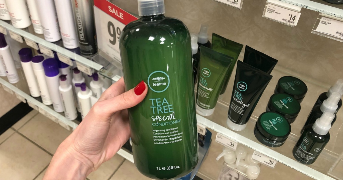 woman's hand holding Paul Mitchell Liter