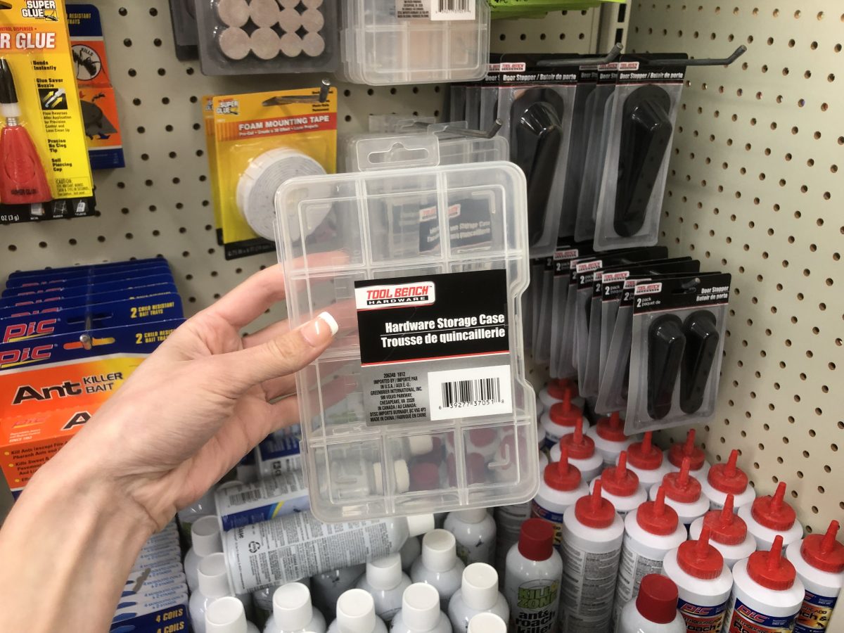 hand holding a hardware storage case in store aisle