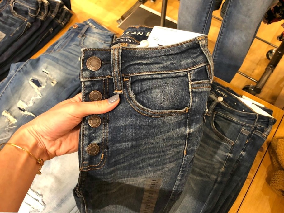 hand holding a pair of AE JEANS