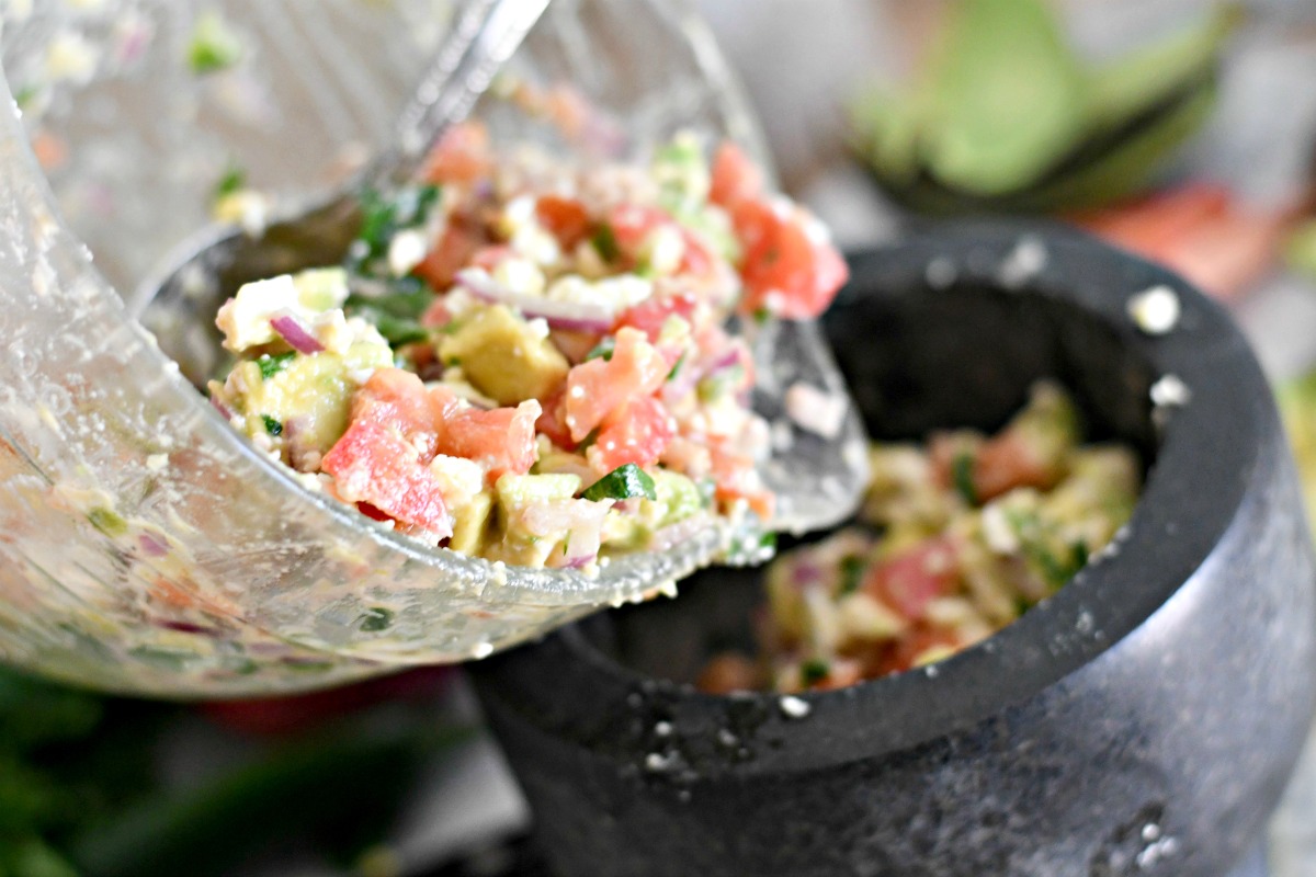 making avocado feta salsa and pouring into bowl