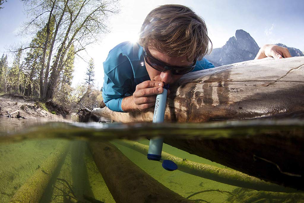 man sipping through lifestraw