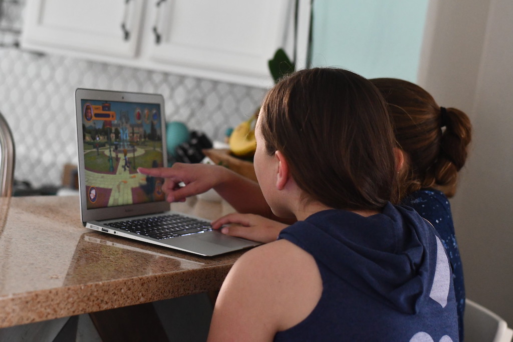 two kids playing video games on computer