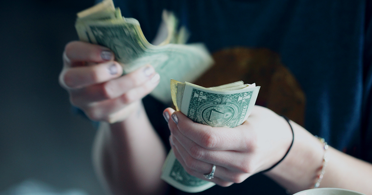 woman counting out dollar bills