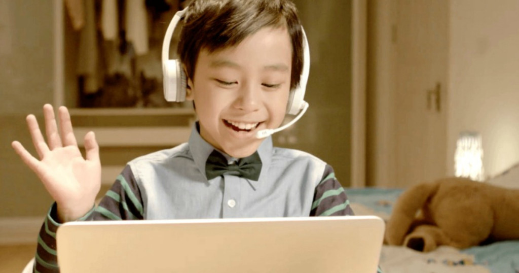 kid wearing headphones and looking at a computer