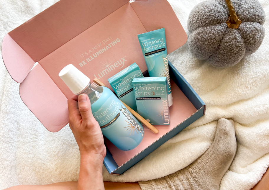 hand reaching for teeth whitening products in pink box 