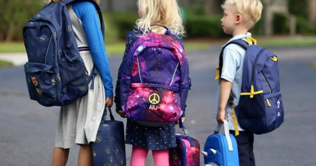 kids wearing backpacks and holding lunchboxes