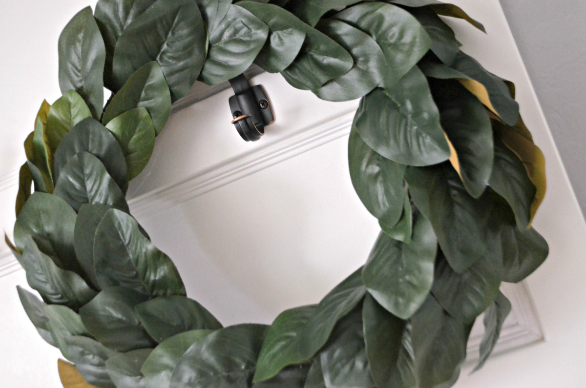 Magnolia wreath hanging on a white door