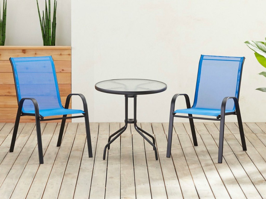 Two Pier1 Imports Sling Dining Chairs in blue on deck w/ a round table